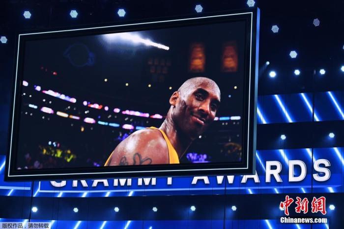 已退役NBA著名球员科比·布莱恩特(Kobe Bryant)当地时间26日在美国加利福尼亚州卡拉巴萨斯市因乘坐的直升机坠毁而遇难，年仅41岁。NBA这一天也有多场比赛进行，各支球队也用着各种方式哀悼科比。同日，美国第62届格莱美音乐奖在洛杉矶举行。 科比的球衣被悬挂在颁奖礼场馆斯台普斯中心，现场临时增加致敬科比环节。图为格莱美颁奖现场大屏幕播放科比生前的画面。